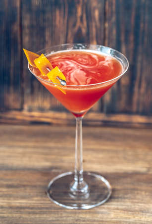 Glass of Blood And Sand Cocktail in martini glass garnished with orange peel