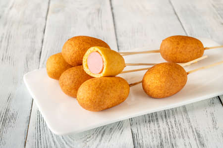 Bunch of mini corn dogs on white serving plateの写真素材