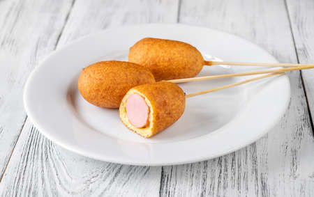 Bunch of mini corn dogs on white serving plateの写真素材