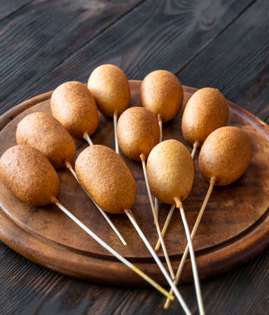 Bunch of mini corn dogs on wooden boardの写真素材