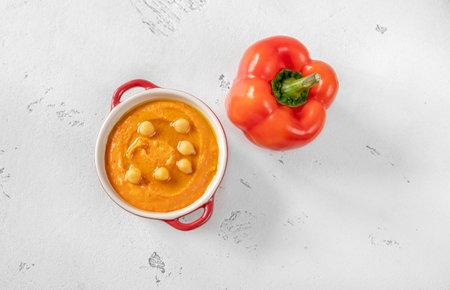 Bowl of paprika hummus with fresh bell peppersの写真素材
