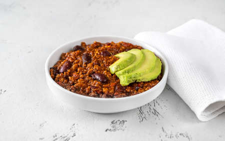 Bowl of chili con carne with slices of avocadoの写真素材