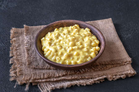 Bowl of macaroni and cheese on black backgroundの写真素材
