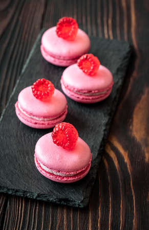 Pink macarons - sweet meringue-based confection decorated with fresh raspberriesの写真素材