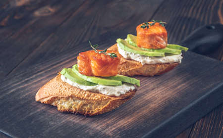Sandwiches with cream cheese, fresh avocado and fried salmon