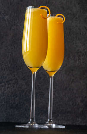 Two glasses of Buck's Fizz cocktail on black backgroundの写真素材