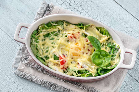 Cheesy baked eggs with spinach and tomatoの写真素材