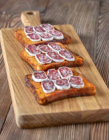 Toasts with fuet on the wooden boardの写真素材