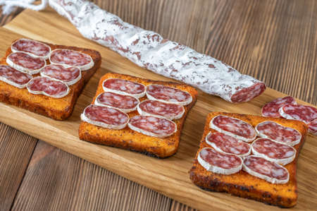 Toasts with fuet on the wooden boardの写真素材