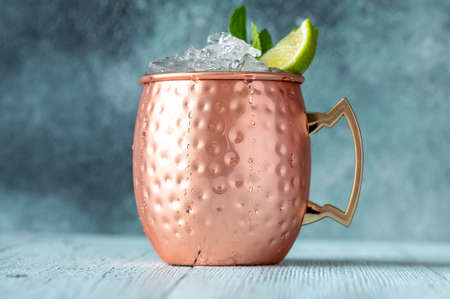 Copper mug of Moscow mule cocktail garnished with mint and limeの写真素材
