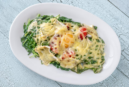 Cheesy baked eggs with spinach and tomatoの写真素材