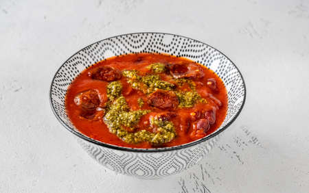 Bowl of kidney bean and chorizo stew garnished with pestoの写真素材