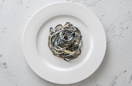Porion of squid ink pasta with creamy sauceの写真素材