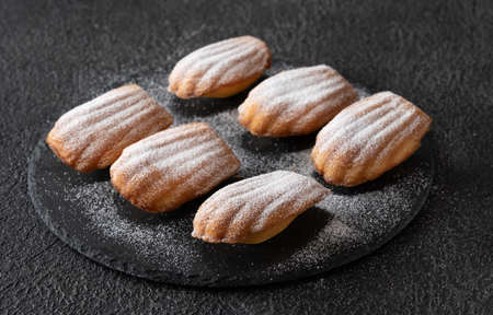 Madeleines - French small sponge cakes on the stone boardの写真素材