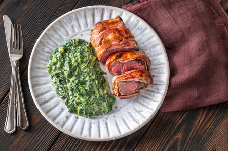 Bacon-wrapped beef steack with creamed spinachの写真素材