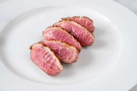 Sliced fried duck breast on the plate