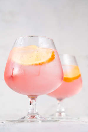 Pink vodka lemonade cocktail garnished with lemon wedgeの写真素材