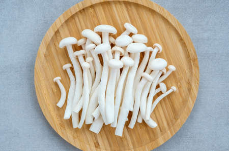 Heap of shimeji white beech mushrooms on wooden tray