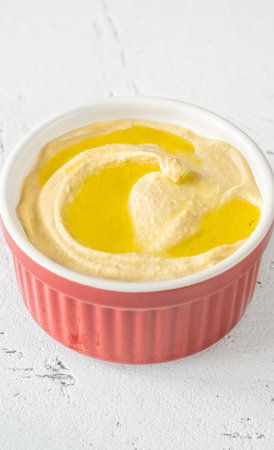 Bowl of hummus garnished with olive oilの写真素材