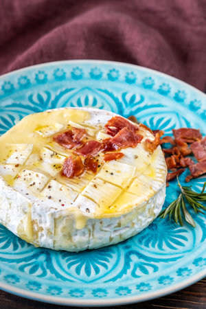 Baked Camembert cheese with crumbled fried baconの写真素材