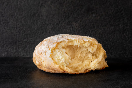 Broken loaf of bread on black background