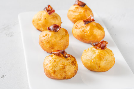 Deep fried potato parmesan balls with glazed baconの写真素材