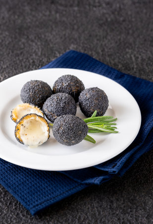 Mozzarella balls breaded with black truffle on the plateの写真素材