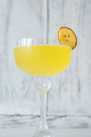 Glass of Bananarama cocktail garnished with banana chunkの写真素材