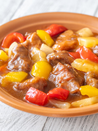 Portion of sweet and sour pork with bell pepper and pineappleの写真素材