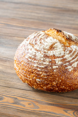 Loaf of sourdough bread on the wooden background