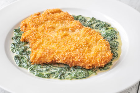 Chicken Milanese cutlet garnished with creamed spinachの写真素材