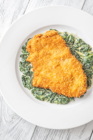 Chicken Milanese cutlet garnished with creamed spinachの写真素材
