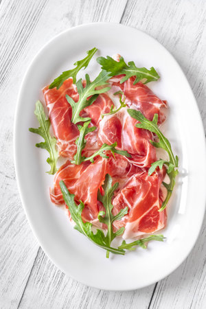 Portion of Prosciutto crudo ham with arugulaの写真素材