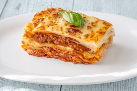 Portion of baked lasagna on the white plateの写真素材