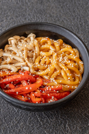 Bowl of udon noodles with bell pepper and mushroomsの写真素材
