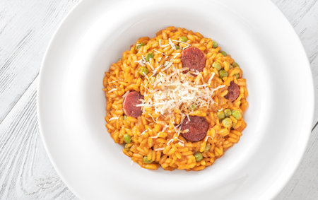 Portion of risotto with chorizo sausage and green peasの写真素材