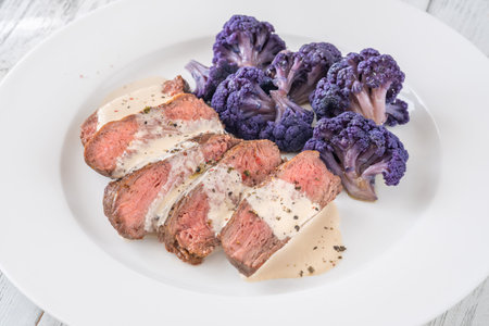 Portion of beef steak with purple cauliflowerの写真素材