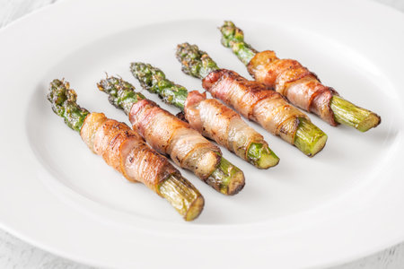 Golden bacon crisps around tender asparagus spears, savory and satisfying combinationの写真素材