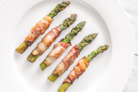 Golden bacon crisps around tender asparagus spears, savory and satisfying combinationの写真素材