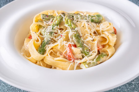 Silky noodles wrapped in sauce, crisp vegetables and cheese complete this comfort dishの写真素材