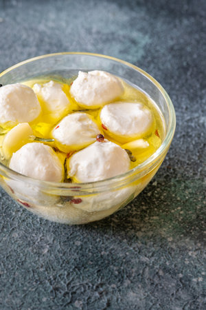 Golden oil swirls around creamy labneh, peppercorns and herbs infuse rustic charmの写真素材