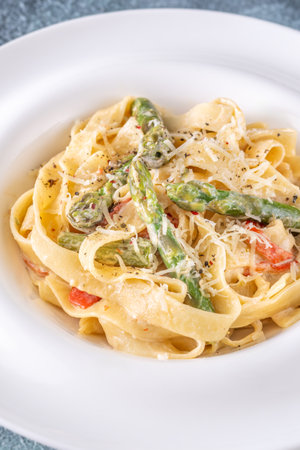 Silky noodles wrapped in sauce, crisp vegetables and cheese complete this comfort dishの写真素材
