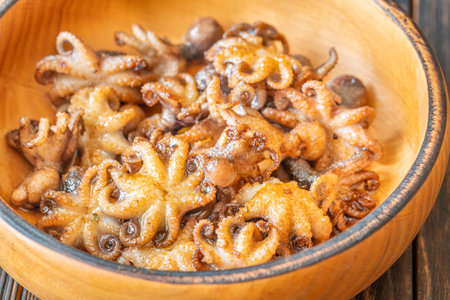 Tender baby octopuses crisped and fragrant, nestled warmly with crunchy garlic finishの写真素材