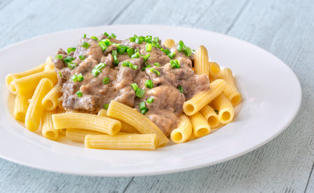 Creamy beef stroganoff over rigatoni, rich sauce, tender meat, and herbsの写真素材