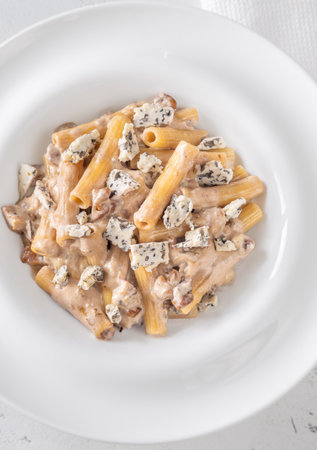 Soft penne coated in rich walnut sauce with crumbled sharp blue cheeseの写真素材