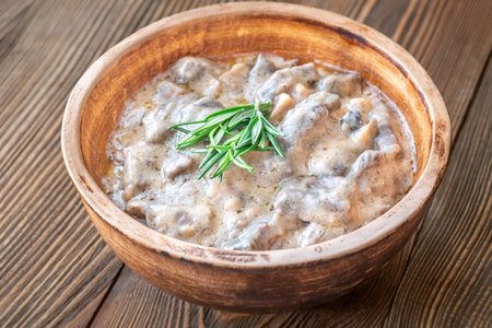 Creamy beef stroganoff with tender meat, rich sauce, and fragrant rosemary garnishの写真素材