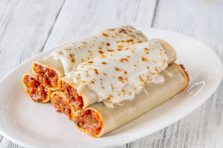 Delicate cannelloni pasta, generously filled with rich bolognese sauce, baked under a blanket of melted mozzarellaの写真素材