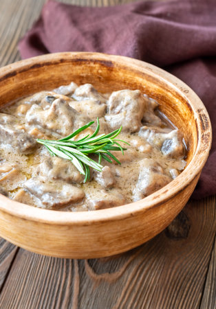 Creamy beef stroganoff with tender meat, rich sauce, and fragrant rosemary garnishの写真素材
