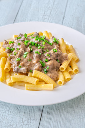 Creamy beef stroganoff over rigatoni, rich sauce, tender meat, and herbsの写真素材