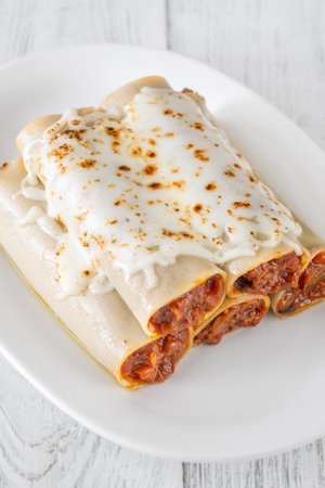 Delicate cannelloni pasta, generously filled with rich bolognese sauce, baked under a blanket of melted mozzarellaの写真素材